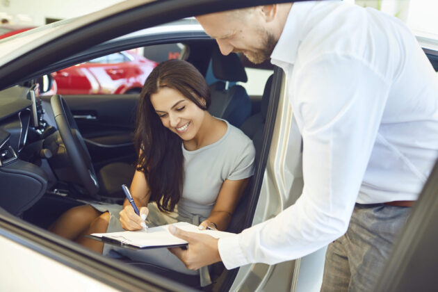 bigstock A Young Woman Buys A Car In A 331622050 1 630x420